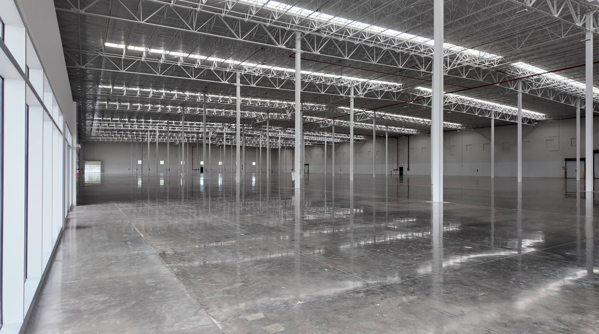 American Industries Shelter Oficial Interior of a Class A industrial warehouse in Mexico showing high clear-height ceilings, polished concrete floors, and dock levelers.